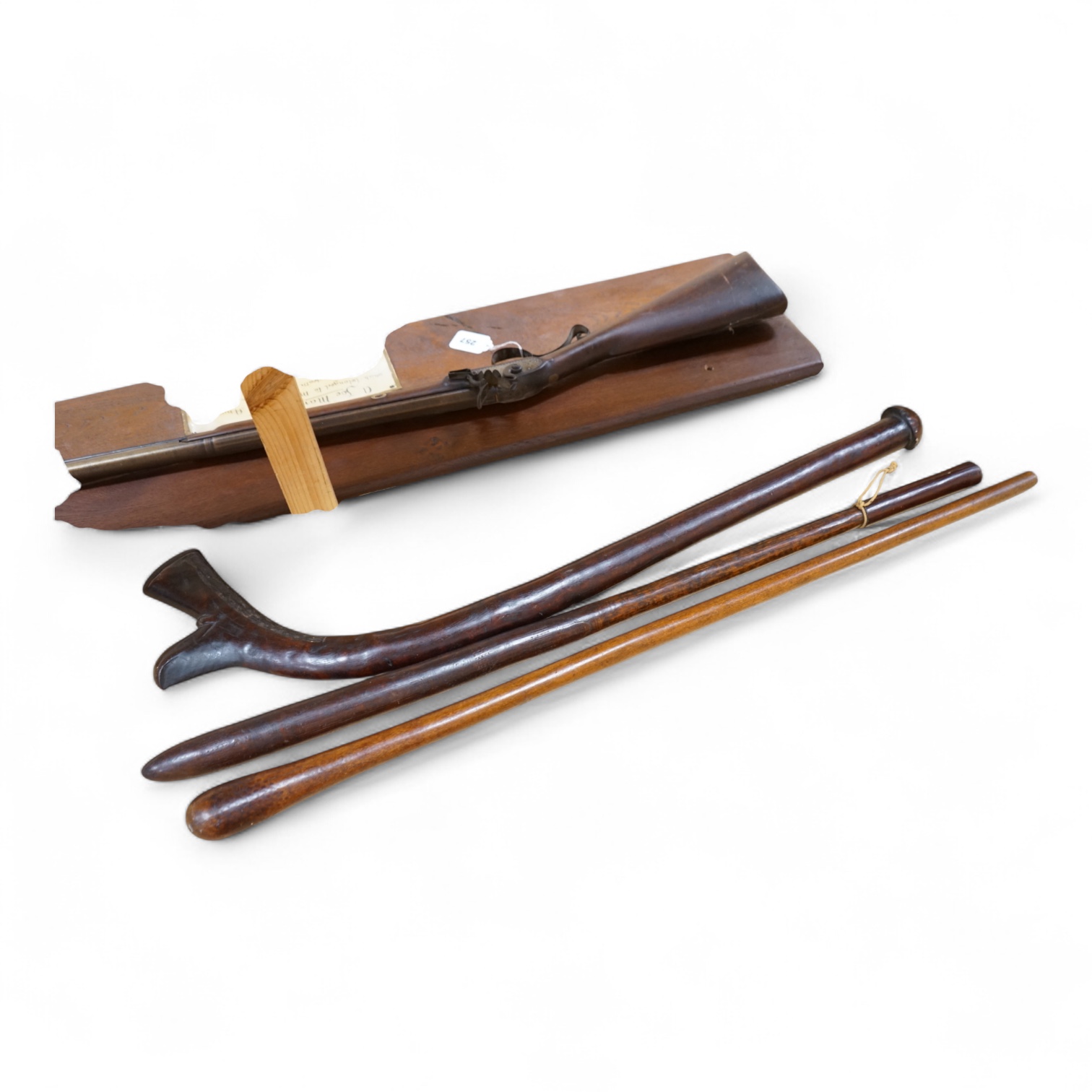 A Fiji hardwood club, probably 19th century or earlier, of gunstock form, overall length 89cm, together with a pole club, probably from Samoa, and a wooden walking stick (3)